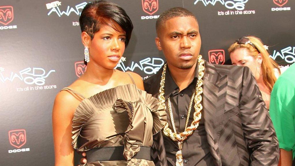 Nas posing on the red carpet alongside his former partner Kelis, both dressed elegantly and smiling for photographers.