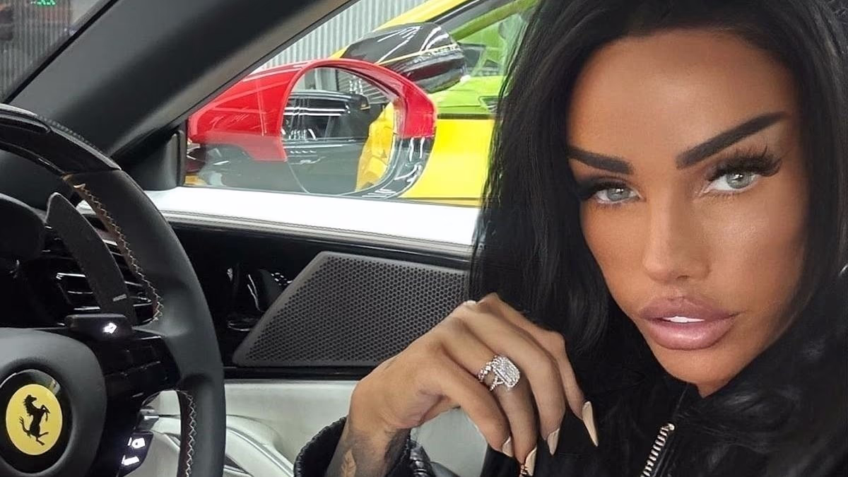 Katie Price sitting in her new $180,000 Ferrari 488 GTB, showing off the red sports car’s interior while smiling for the camera.
