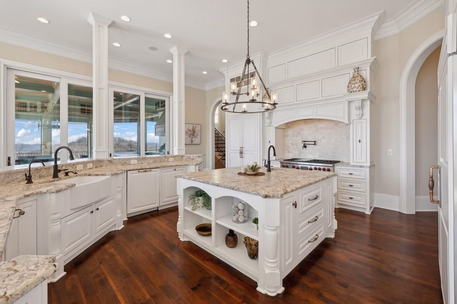 A spacious, modern kitchen with high-end appliances, granite countertops, and a large island in Dave Ramsey’s Tennessee estate.