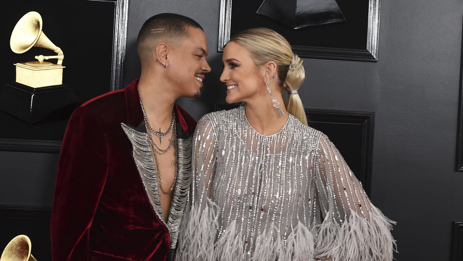 Ashlee Simpson and Evan Ross pose together on the Grammys red carpet, dressed in coordinating high-fashion ensembles.