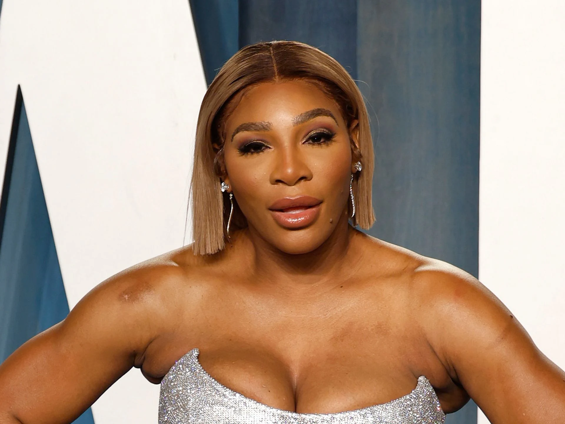 Serena Williams looking stunning and glamorous in an elegant gown while posing on the red carpet at a major event.