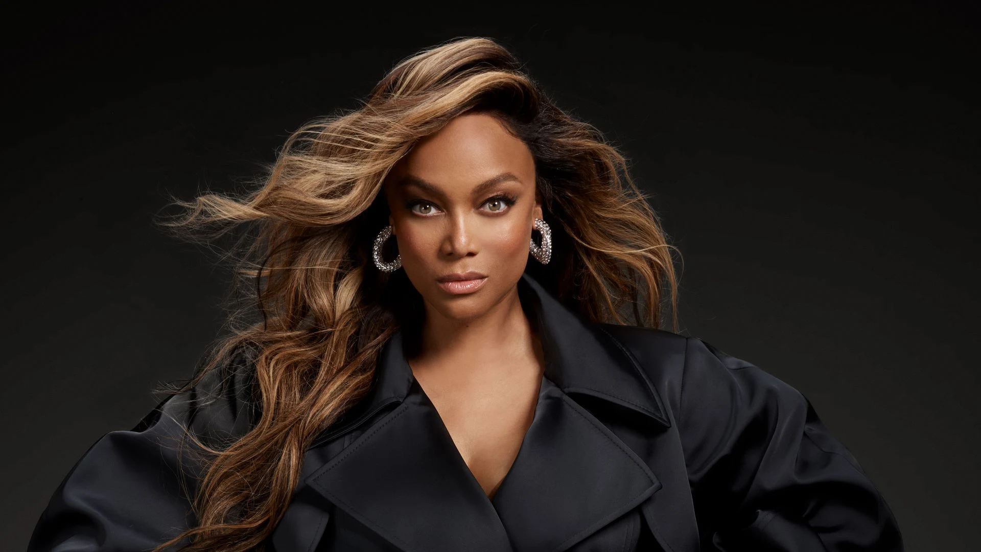 Tyra Banks posing elegantly, fully glammed up for a high-fashion photo shoot.