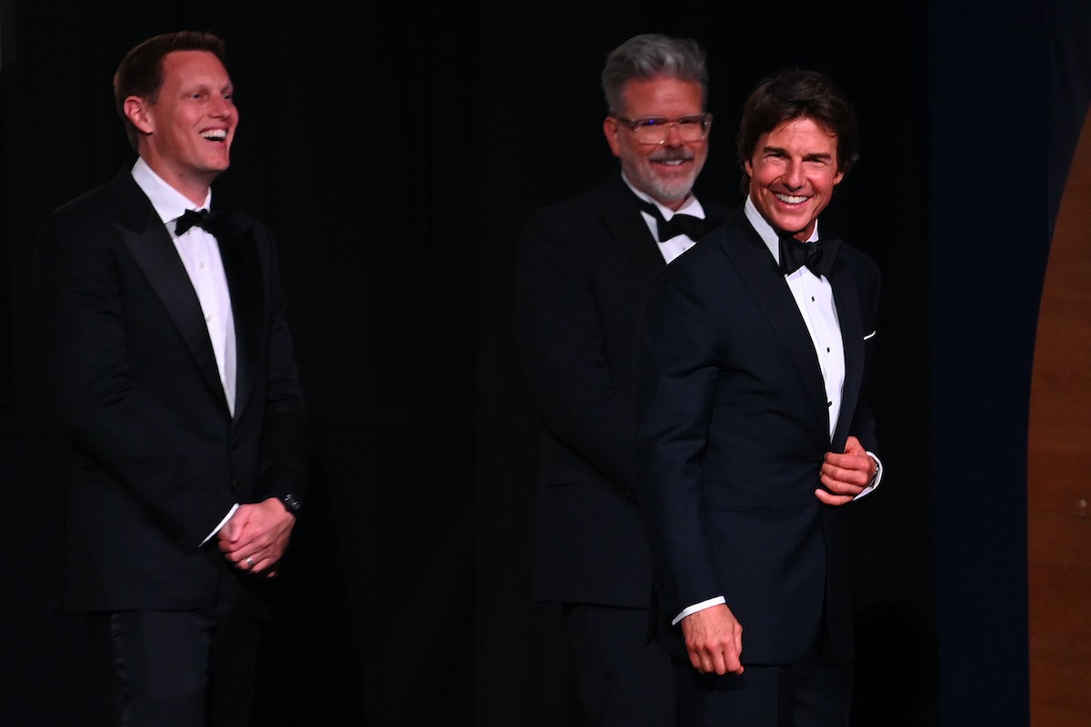 David Ellison standing on stage beside Tom Cruise during a film event.