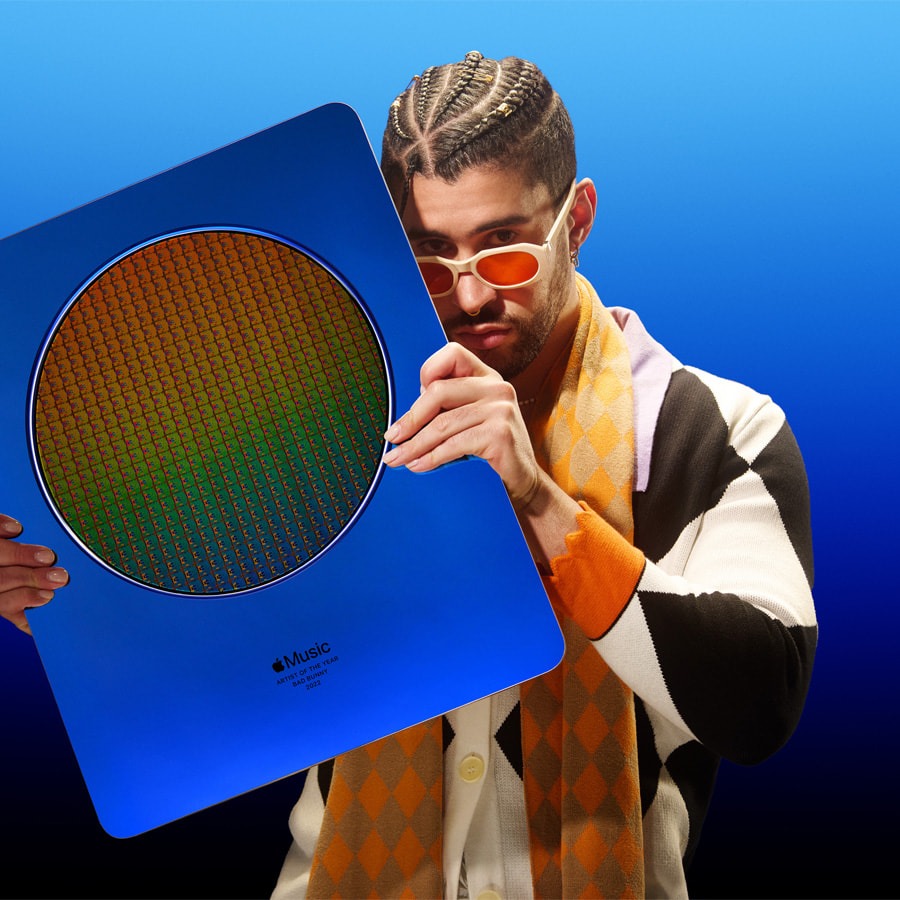 Bad Bunny smiling and holding his Apple Music Artist of the Year 2022 award on stage.