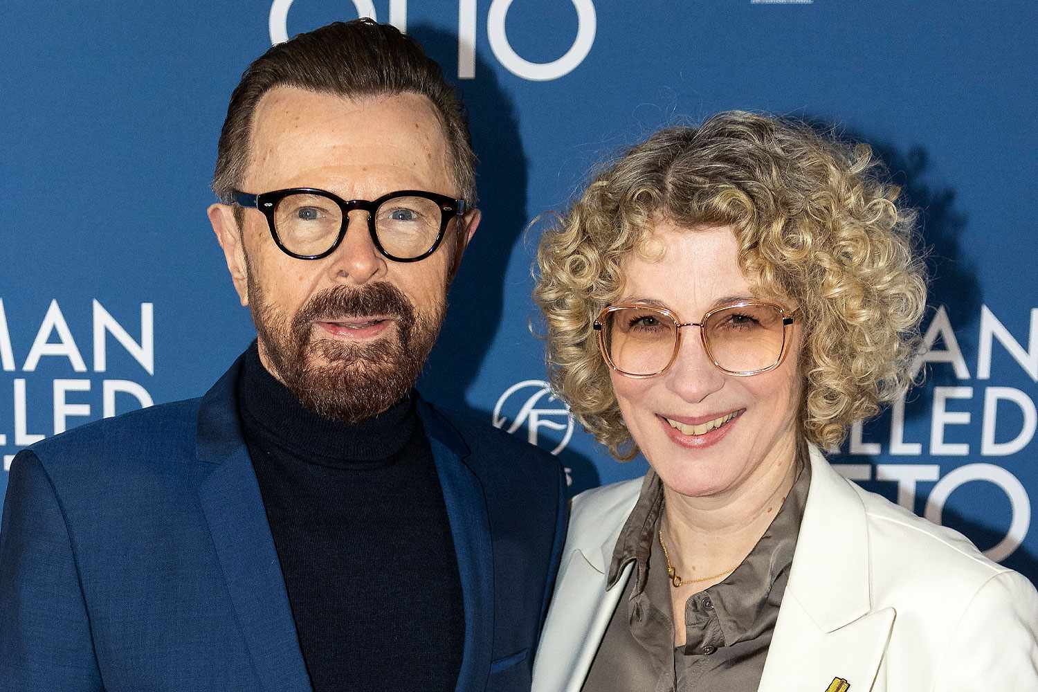 Björn Ulvaeus smiling warmly alongside his wife Lena Källersjö, who is 28 years younger, posing together at a formal event.
