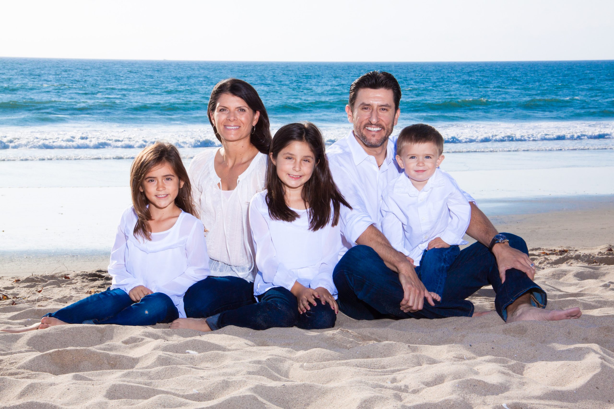 Mia Hamm posing for a photo with her family on the beach.