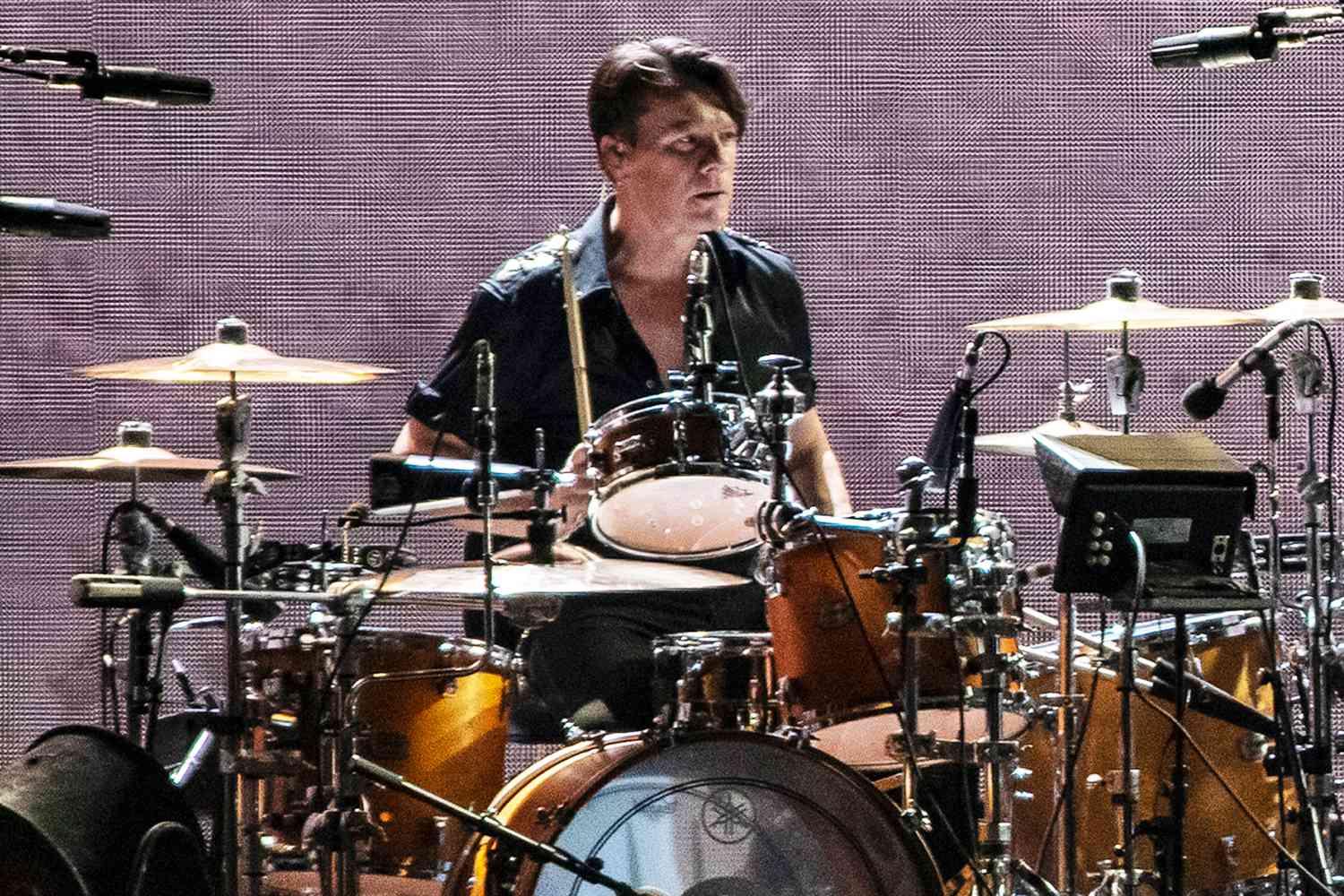 Larry Mullen Jr. seated at his drum kit, focused during a live U2 performance.