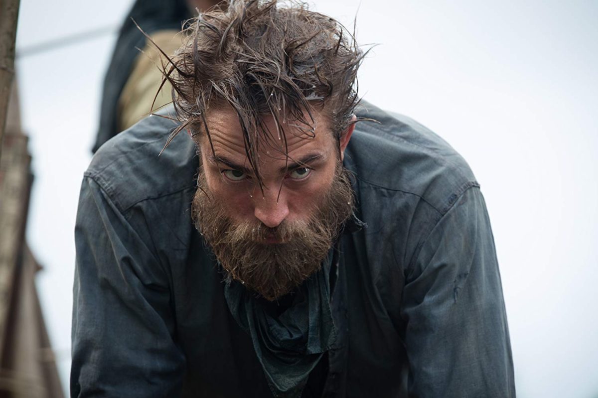 Robert Pattinson in The Lost City of Z, wearing early 20th-century explorer attire in an ocean setting.