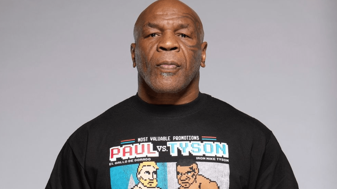 Man wearing a black T-shirt featuring retro-style cartoon boxers and the text “Paul vs. Tyson.”