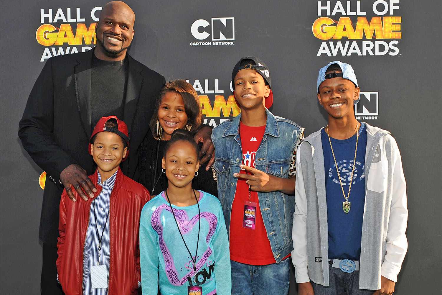 Shaquille O’Neal posing with five of his children on the red carpet at the Hall of Game Awards, all smiling for the cameras.