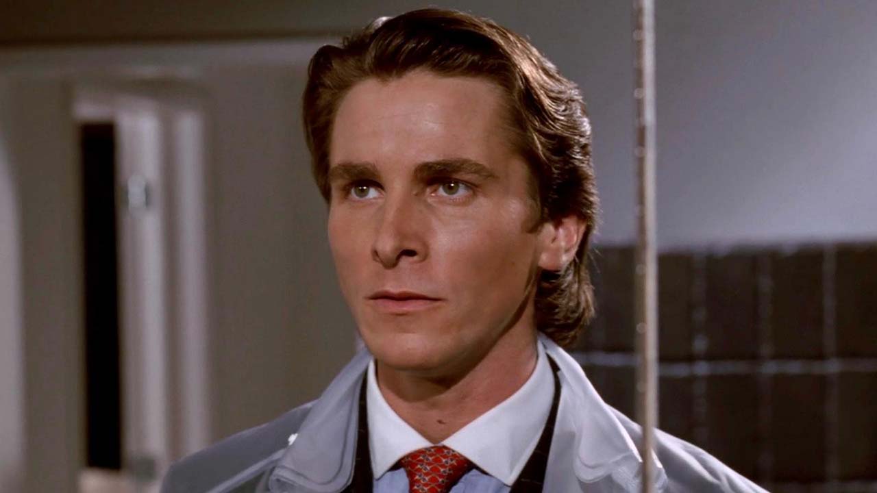 Christian Bale portraying Patrick Bateman in American Psycho, dressed sharply with a cold, intense expression.