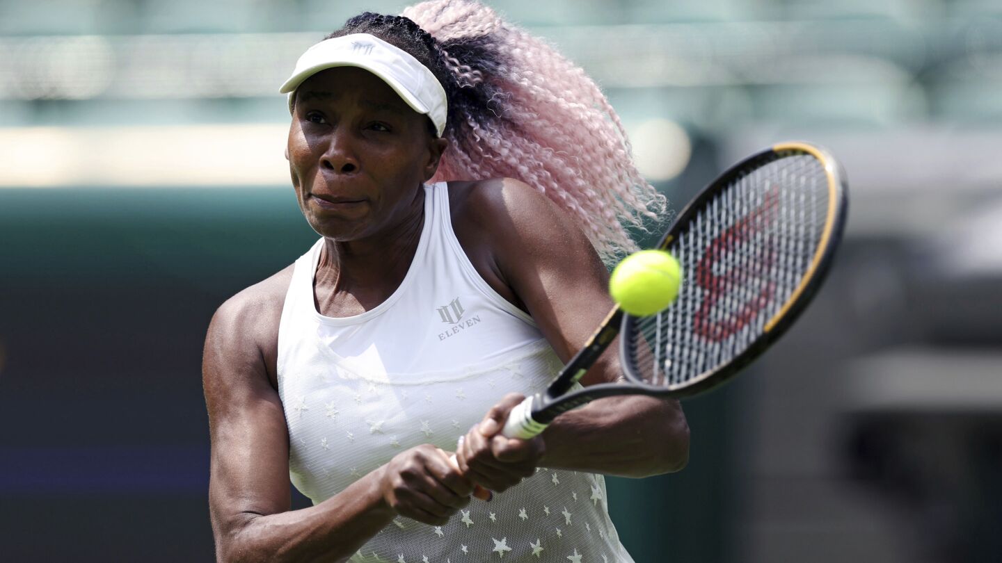 Venus Williams mid-swing during a powerful forehand shot on the tennis court, showcasing her athleticism and focus.