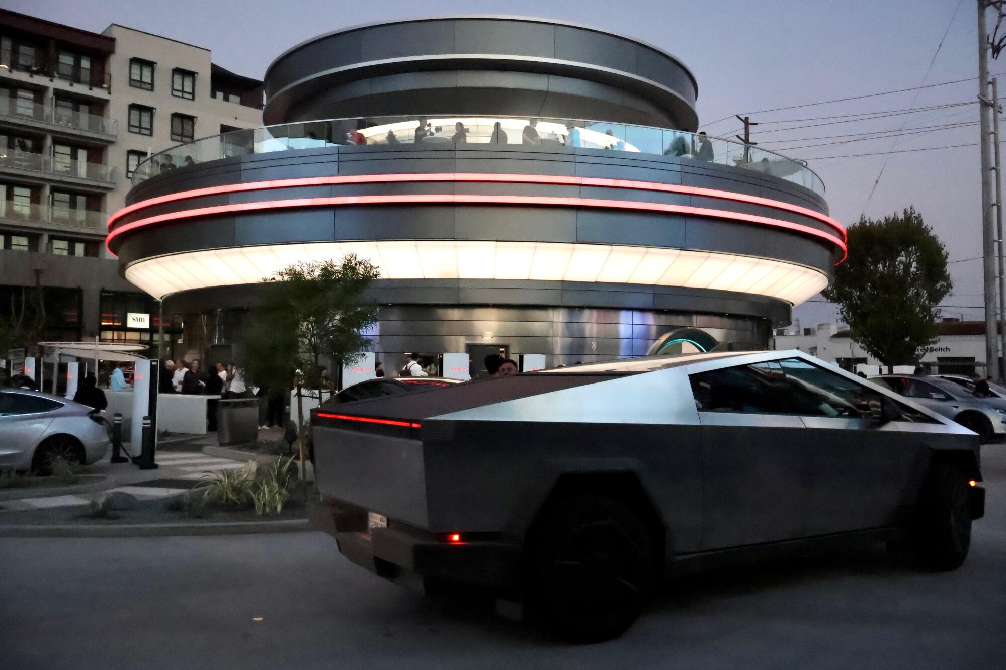 Exterior of Elon Musk’s retro-futuristic Tesla Diner in Los Angeles, featuring a sleek silver design and Tesla Superchargers.