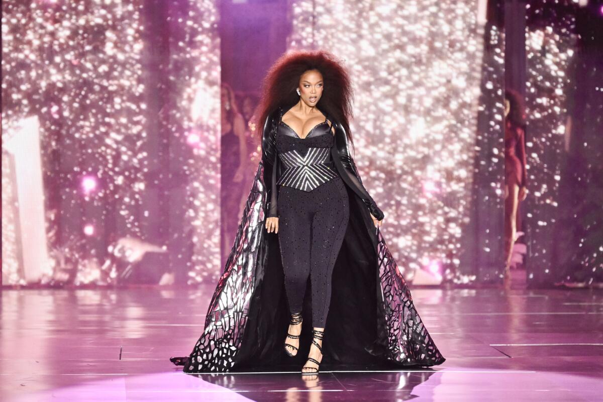 Tyra Banks confidently strutting down the runway during a live fashion show.