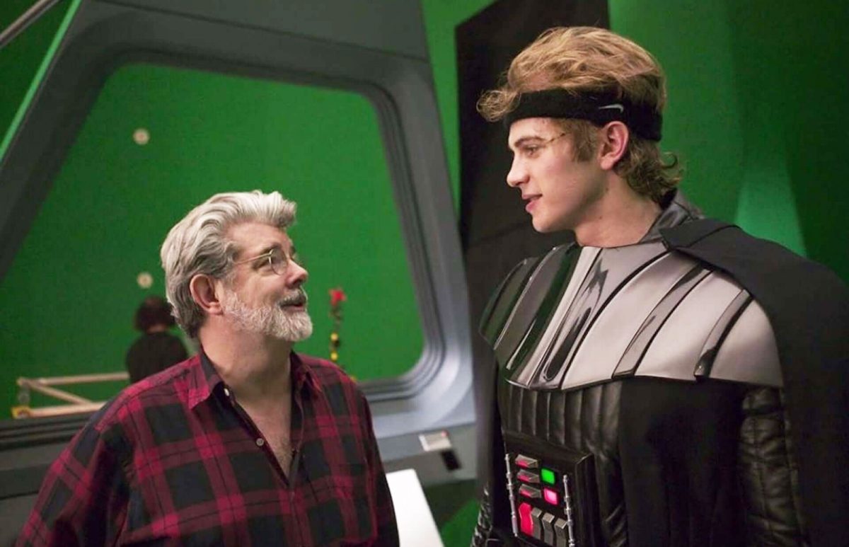 Hayden Christensen in full Darth Vader costume on set, speaking with director George Lucas during a break in filming.