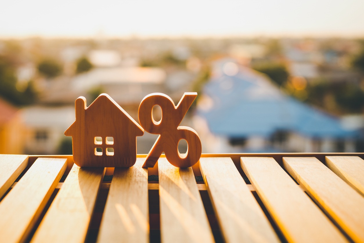 percentage and house sign symbol icon wooden on wood table. concepts of home interest, real estate, investing in inflation.