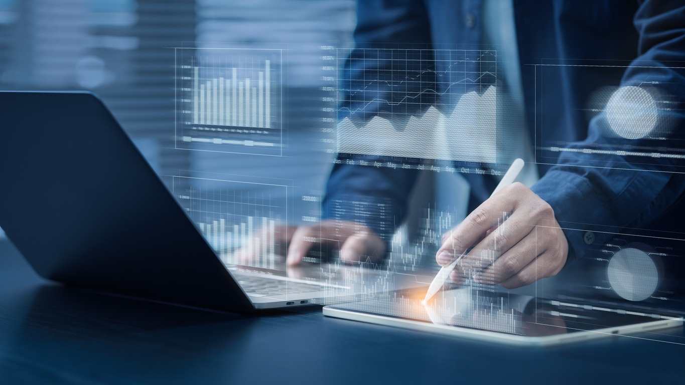 businessman uses computer with pen. financial graph analysis concepts stock market information. reporting and statistics including kpi analysis on a blue background.
