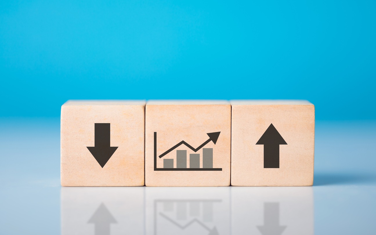 upward and downward arrows alongside a financial graph drawn on wooden blocks, symbolizing the concept of financial profit and loss. fluctuating nature of markets and the dynamics of financial growth