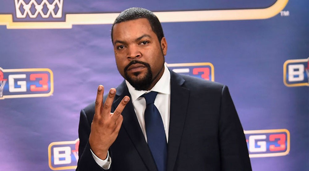 Ice Cube holding up three fingers during a public event for the BIG3 league, symbolizing the 3-on-3 basketball format.
