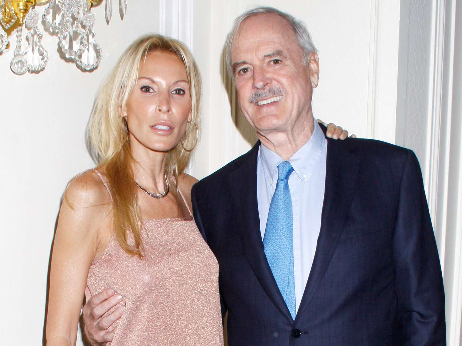 John Cleese smiling warmly alongside his wife Jennifer Wade at a public event.