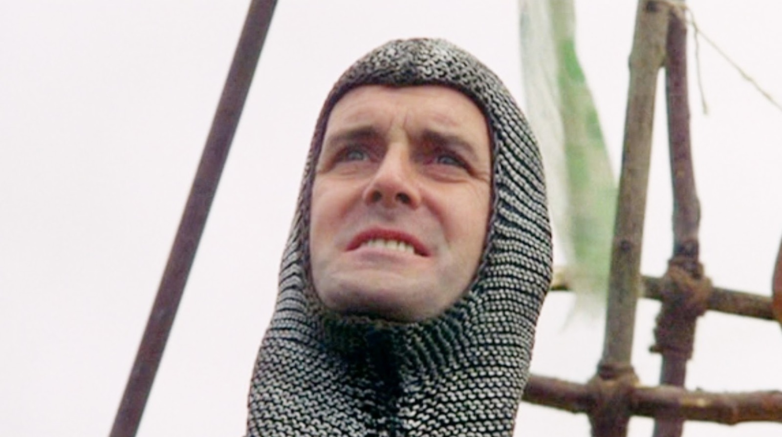 John Cleese wearing chain mail on his head as a knight in a Monty Python sketch.