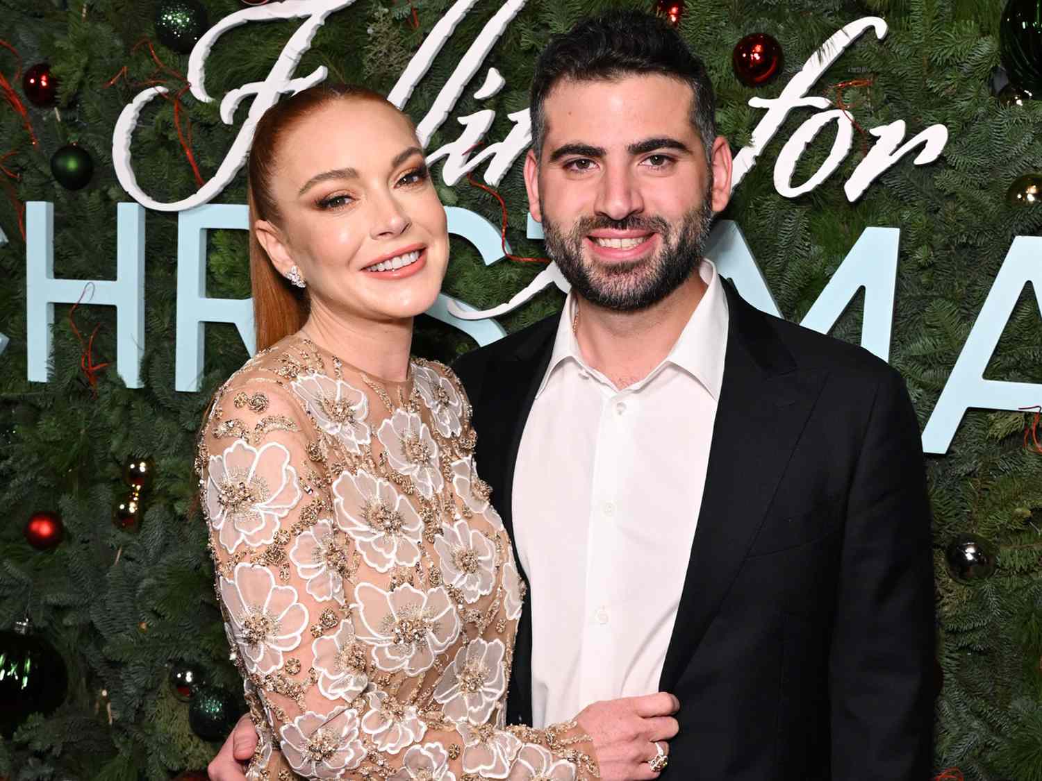 Lindsay Lohan smiling alongside her husband, both looking happy and relaxed in a candid moment.