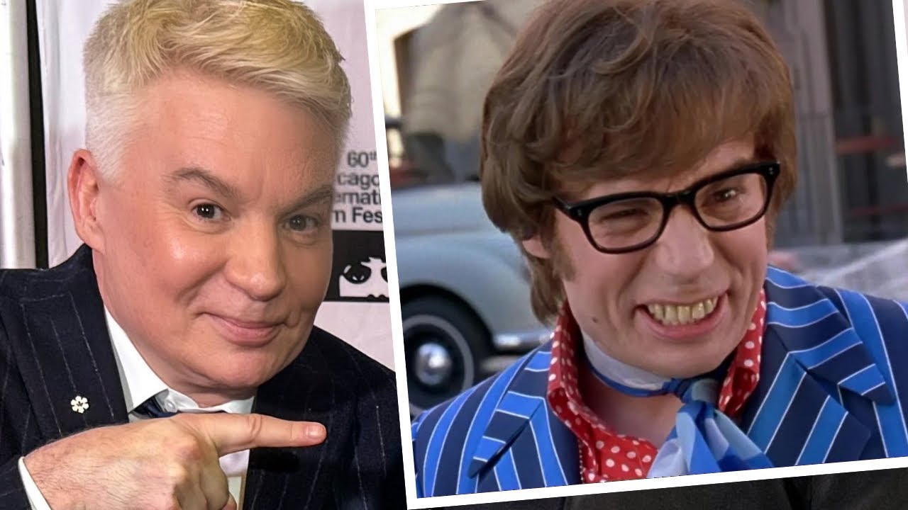 Mike Myers smiling and pointing to a picture of his character Austin Powers