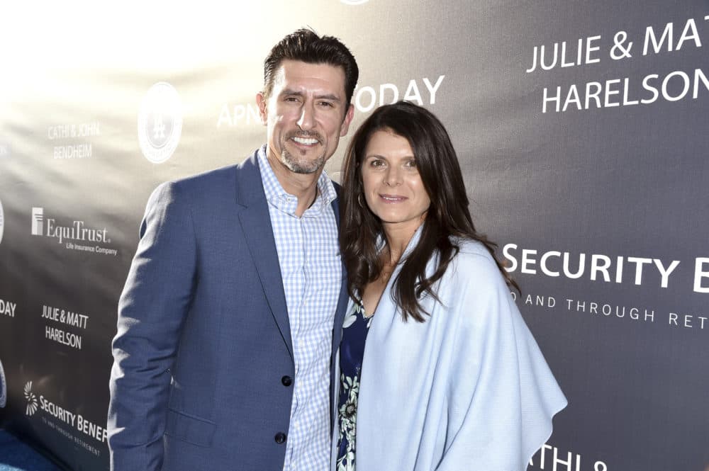 Mia Hamm and her husband Nomar Garciaparra smiling together on the red carpet.