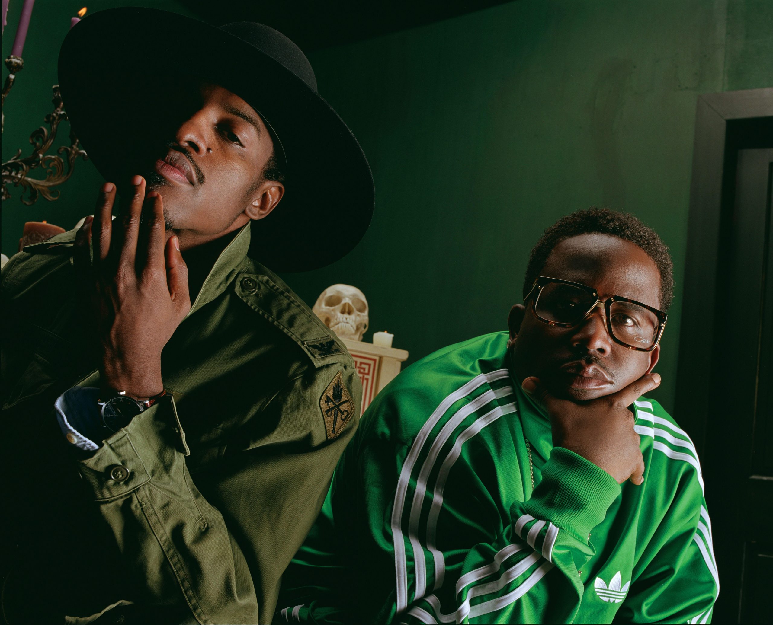 OutKast posing in coordinated green outfits during a stylized photo shoot, showcasing their bold fashion and creative flair.