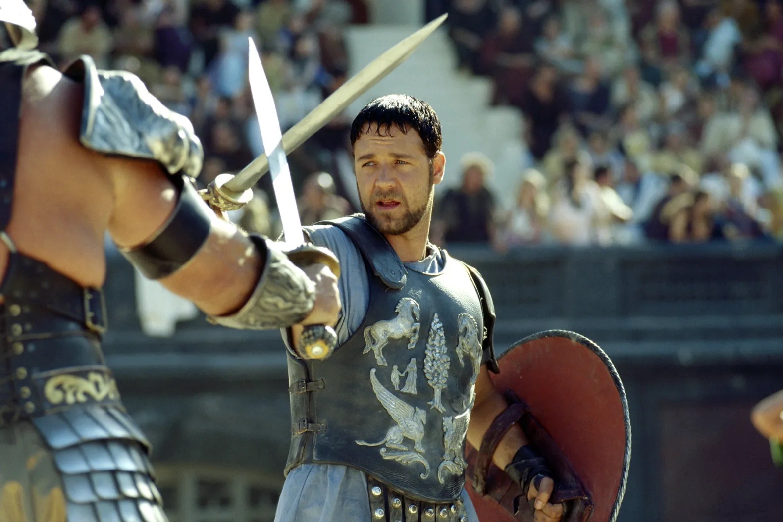 Russell Crowe as Maximus in Gladiator, wearing Roman armor and holding a sword during a battle scene.