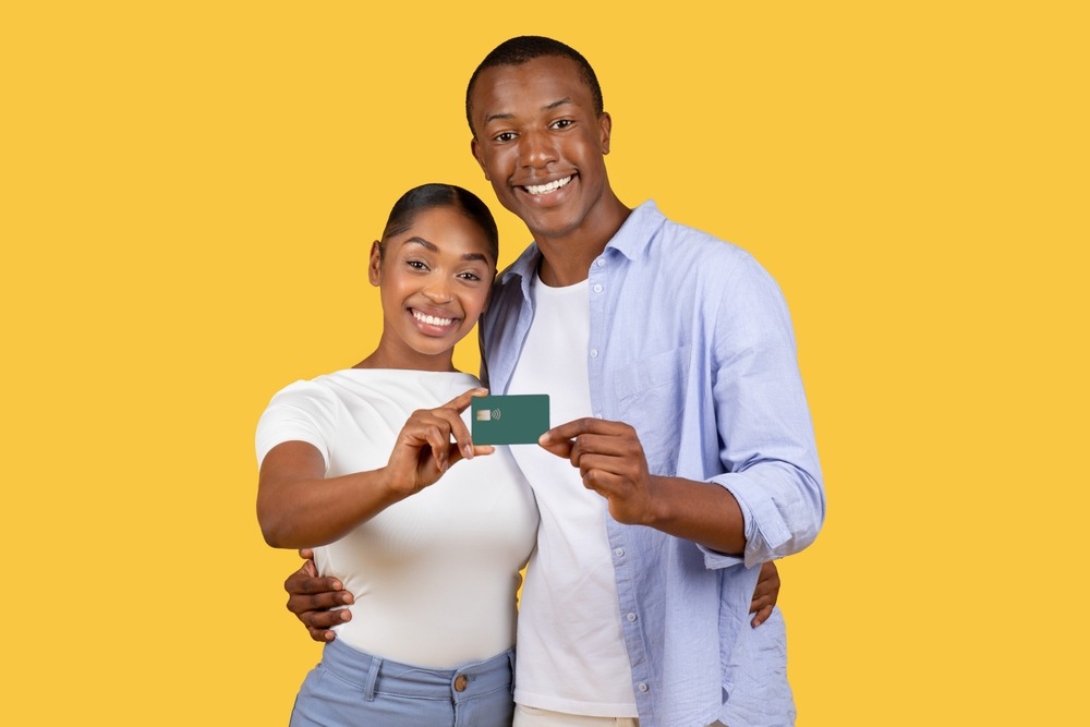 smiling,young,black,couple,jointly,presenting,bank,card,,looking,happy