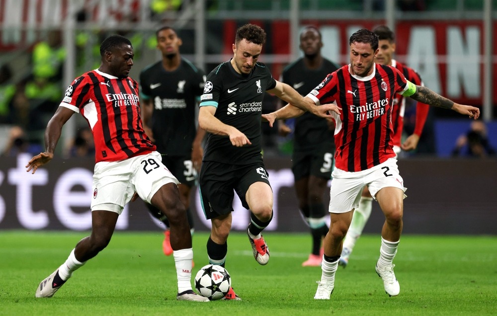 Diogo Jota using his skill to dribble past two opposing players during a Liverpool match.