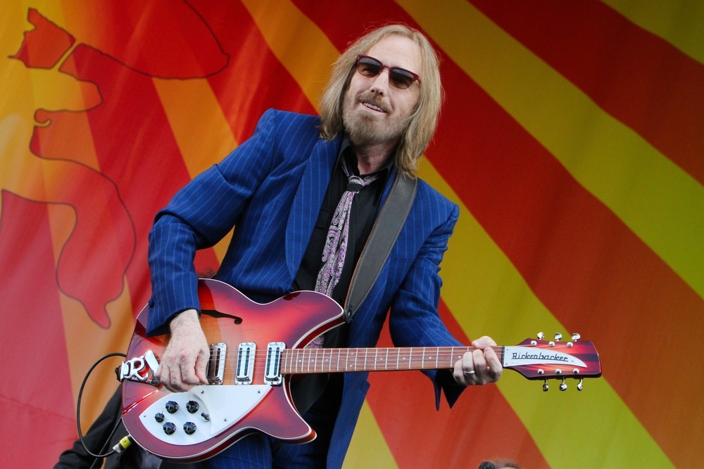 Tom Petty performing live at a music festival, engaging a massive crowd with his signature rock sound.