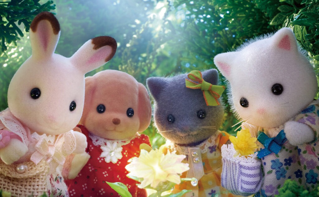 Four Sylvanian Families characters standing together outdoors in colorful outfits.