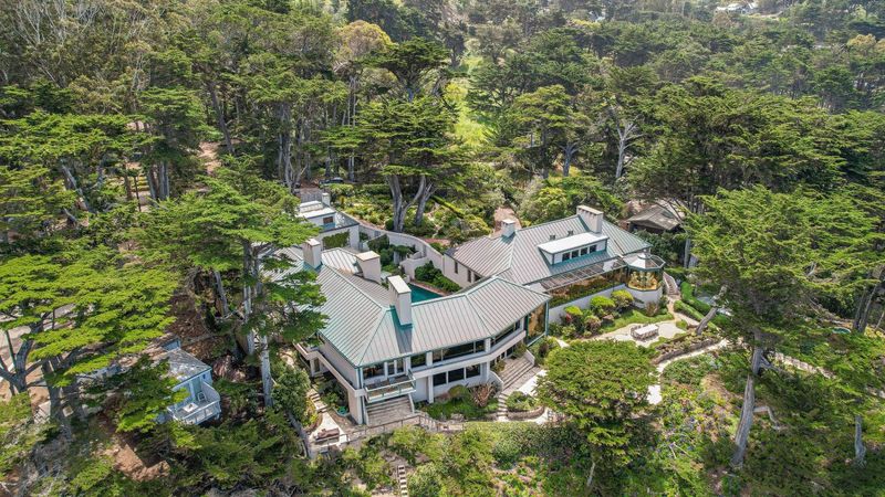 Aerial view of the oceanfront Carmel Highlands estate featured in Basic Instinct, showcasing the cliffside location, main house, and surrounding cottages.