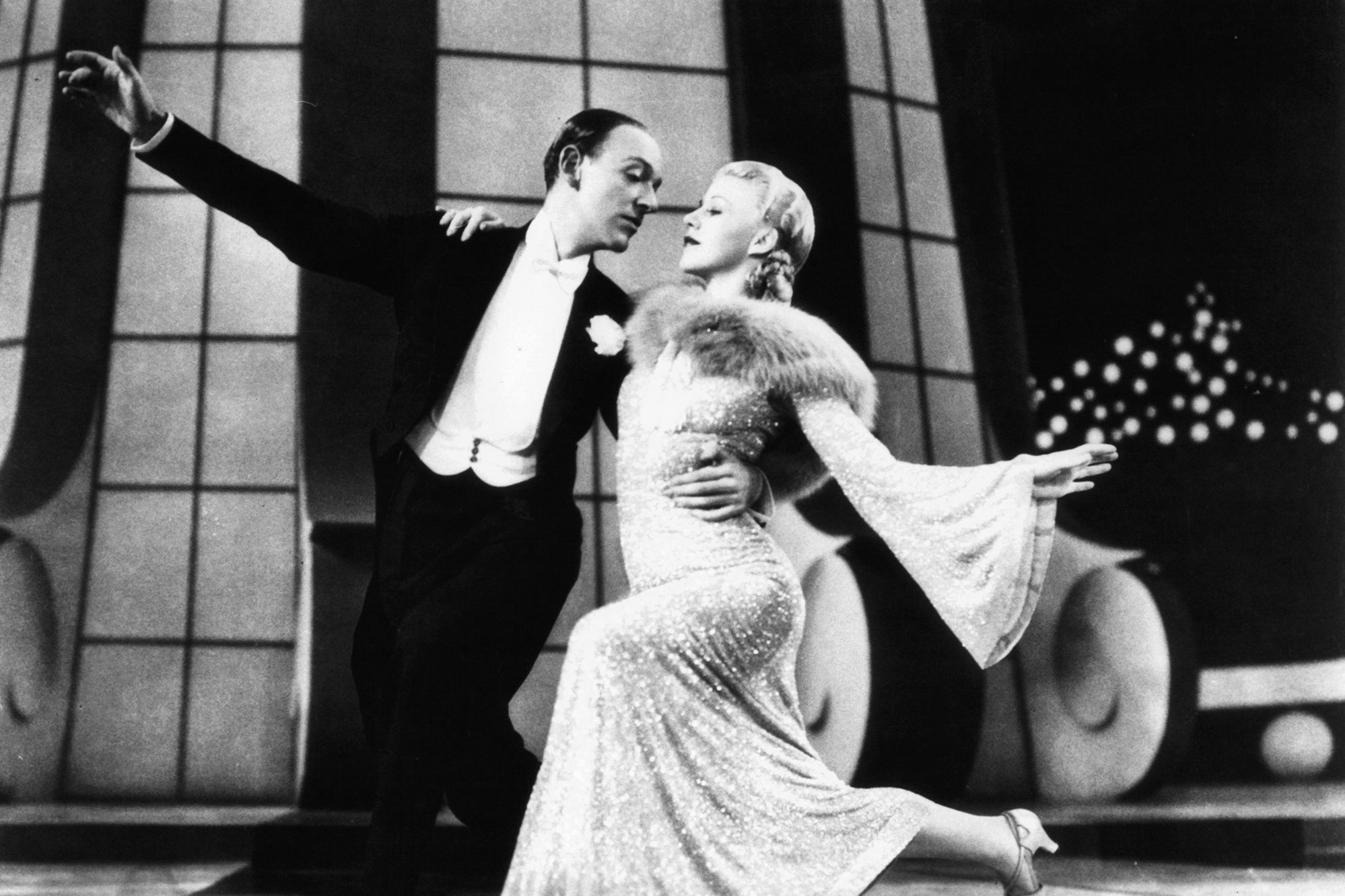 Ginger Rogers and Fred Astaire striking a graceful pose at the end of a dance routine during a performance.