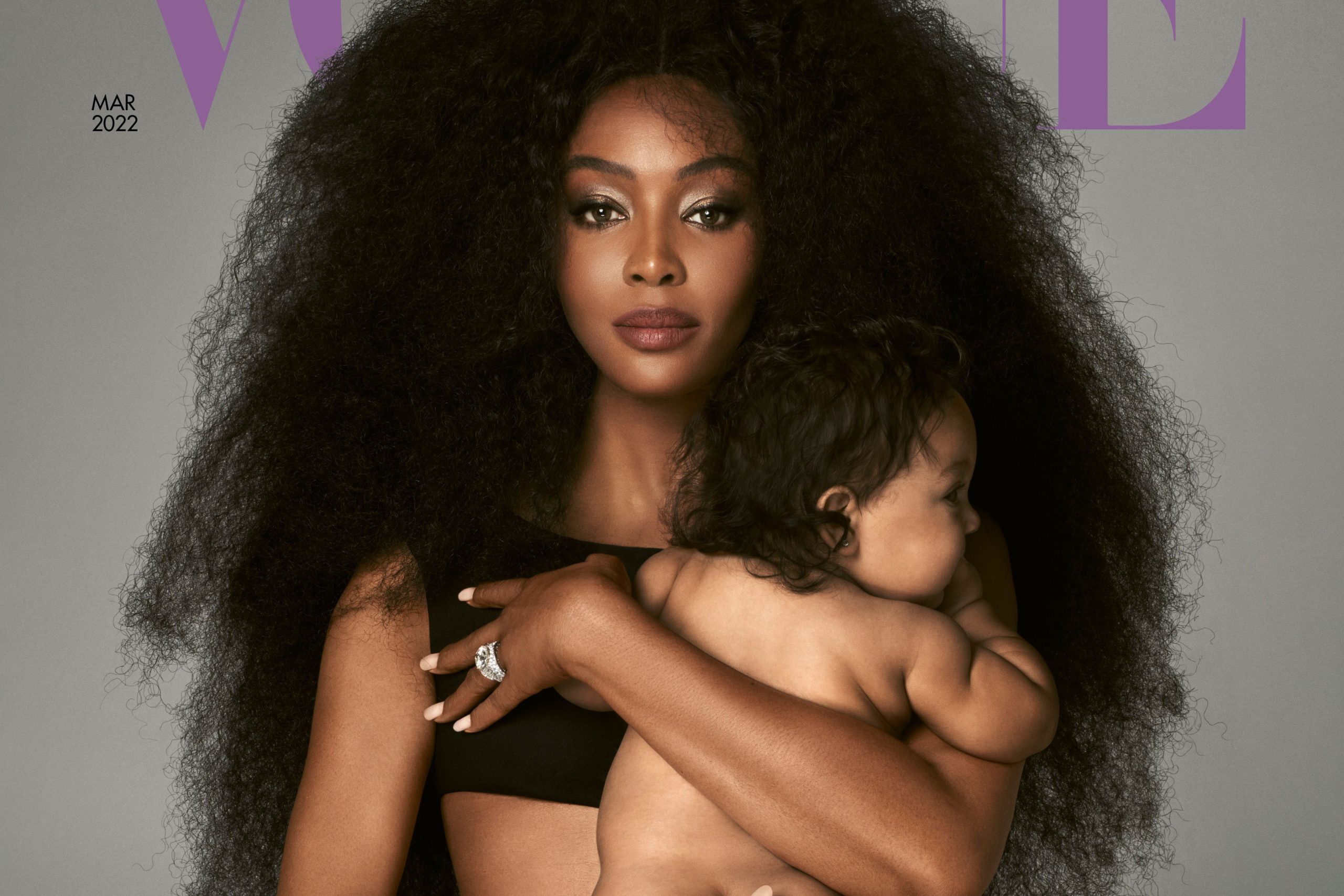Naomi Campbell holding her baby on the cover of Vogue, radiating elegance and maternal warmth.