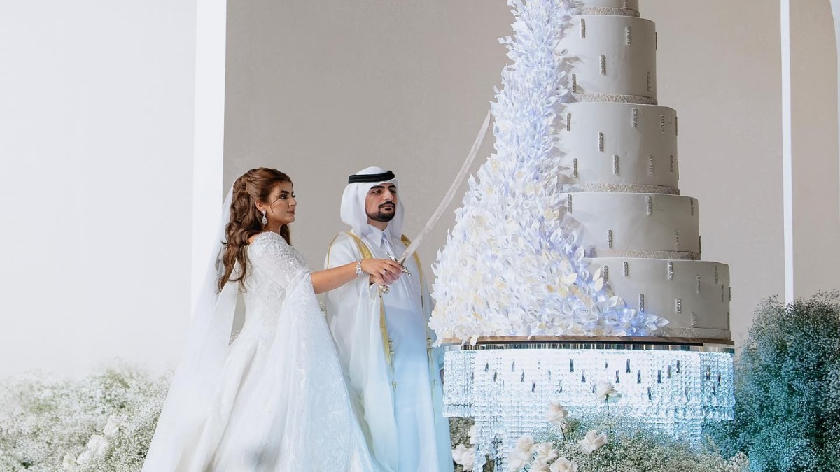 Princess Sheikha Mahra and her ex-husband cutting their wedding cake together.