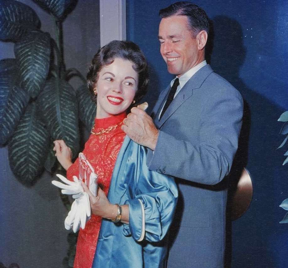 Shirley Temple smiling alongside her husband, both looking happy together.