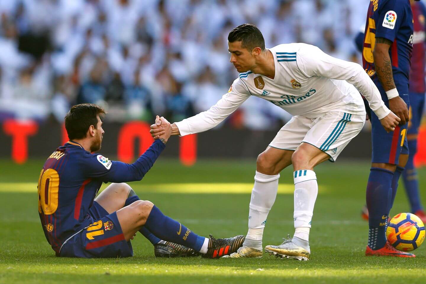 Cristiano Ronaldo helping Lionel Messi off the floor during an El Clásico match.