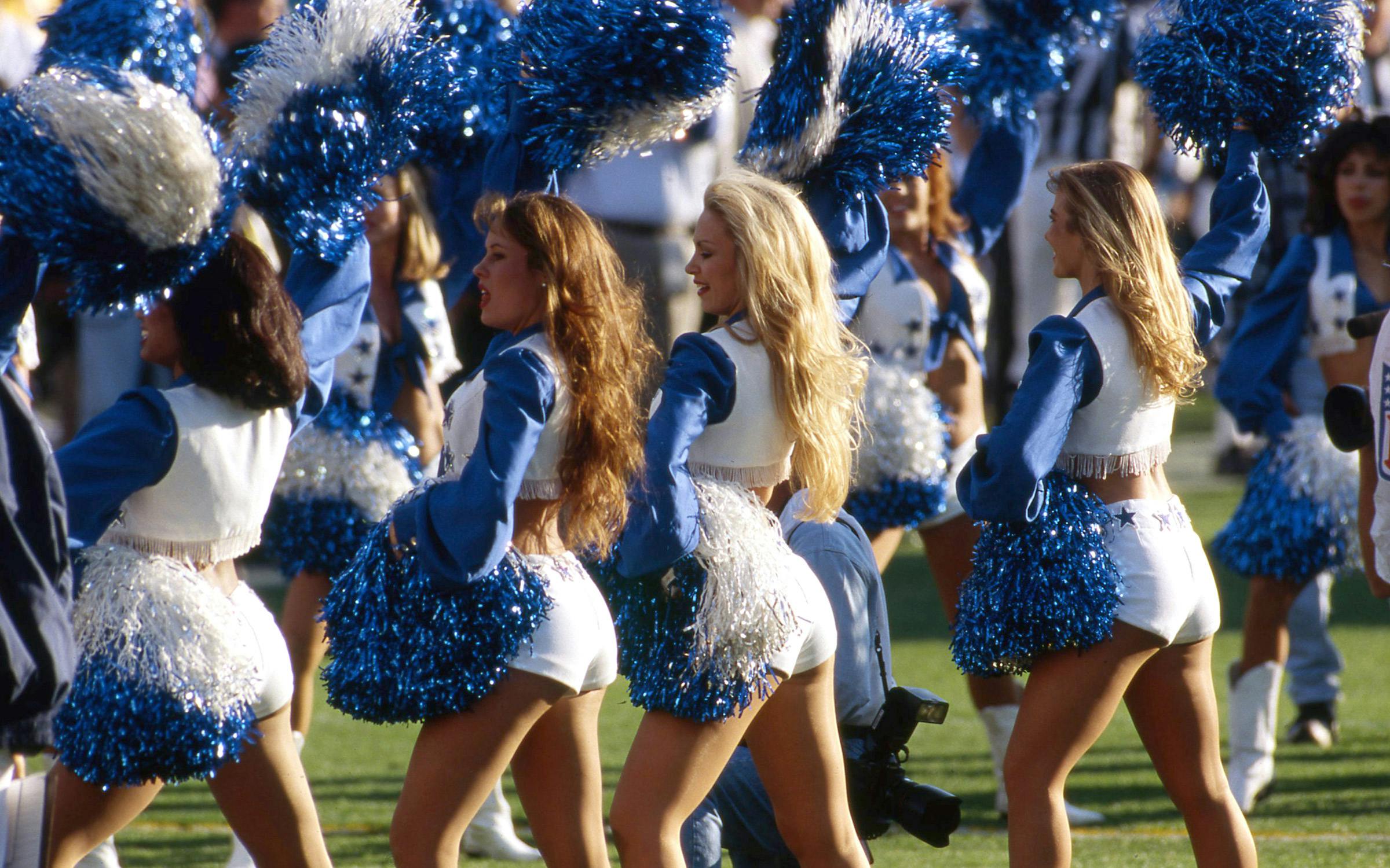 The original Dallas Cowboys Cheerleaders performing on the field in the 1970s with their iconic uniforms.