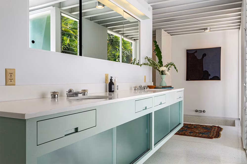 Bathroom in Brad Pitt’s former Steel House featuring his-and-hers sinks, light-blue cabinetry, and modern midcentury design.