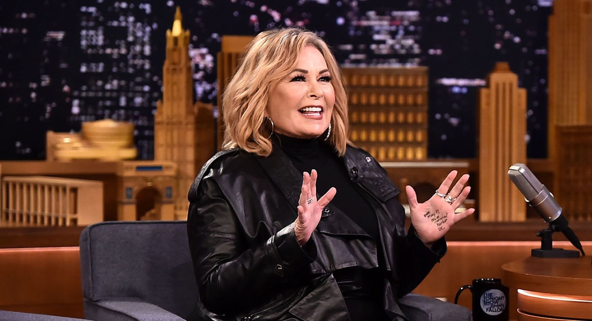 Roseanne Barr being interviewed on a late-night Saturday TV show, laughing during the conversation.