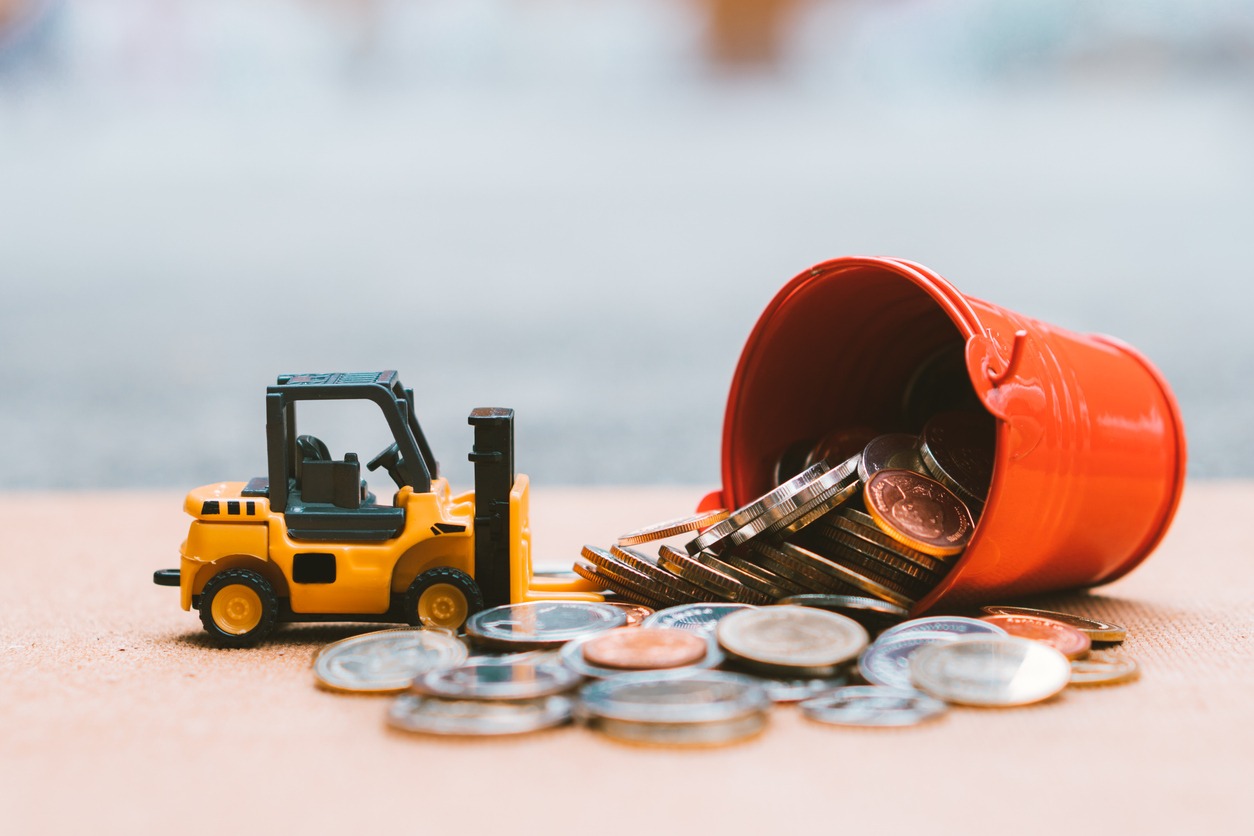 closeup stack coins with construction vehicle
