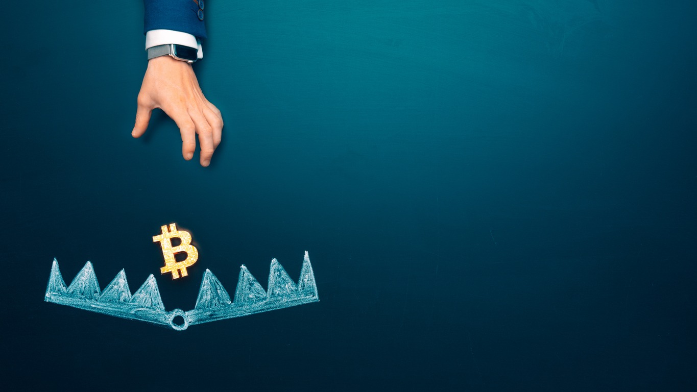 trapped concept. bitcoin as a bait. cryptocurrency into the bear trap. businessman hand trying to reach the money trap with bitcoin. copy space