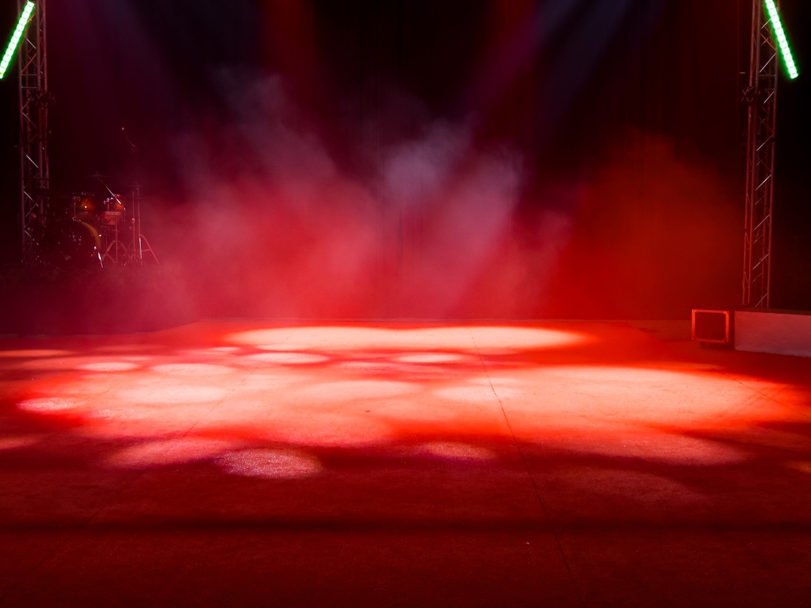 empty stage with red lights and smoke effects in theater setting