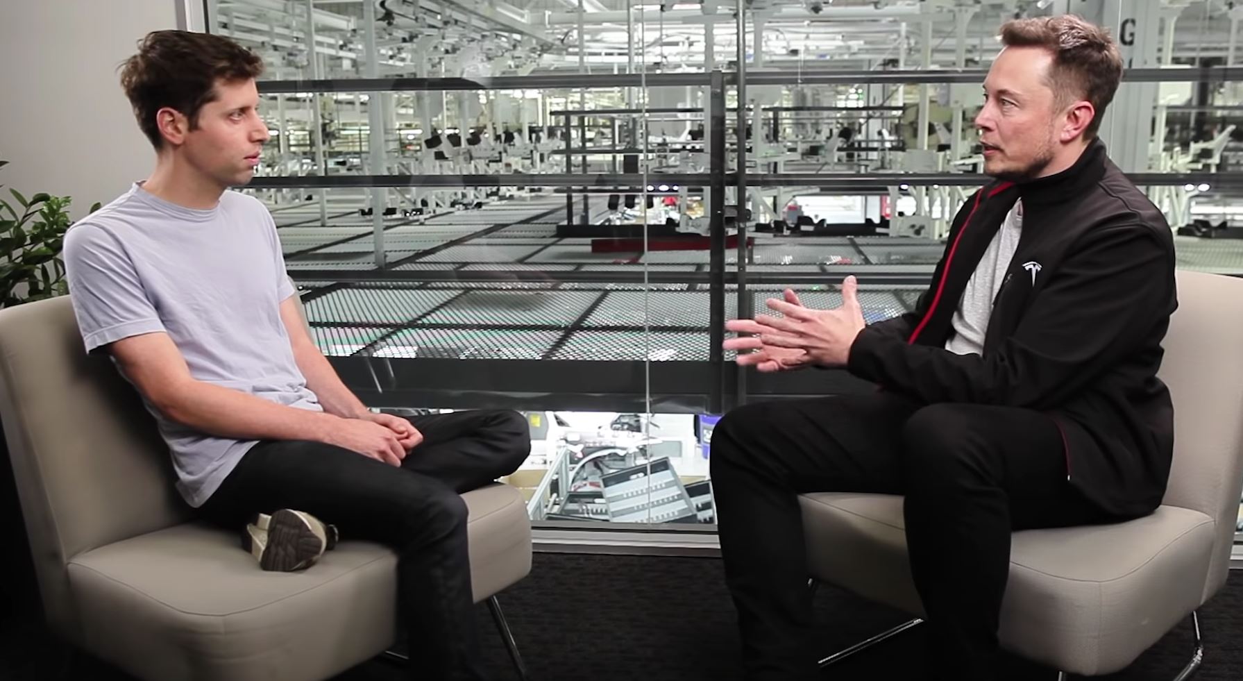 Elon Musk interviewing Sam Altman on stage, engaging in a discussion about AI and the future of technology.