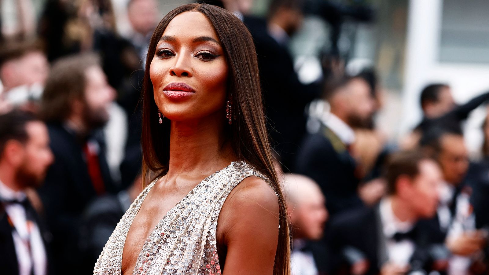 Naomi Campbell posing elegantly on the red carpet in a stunning designer gown.