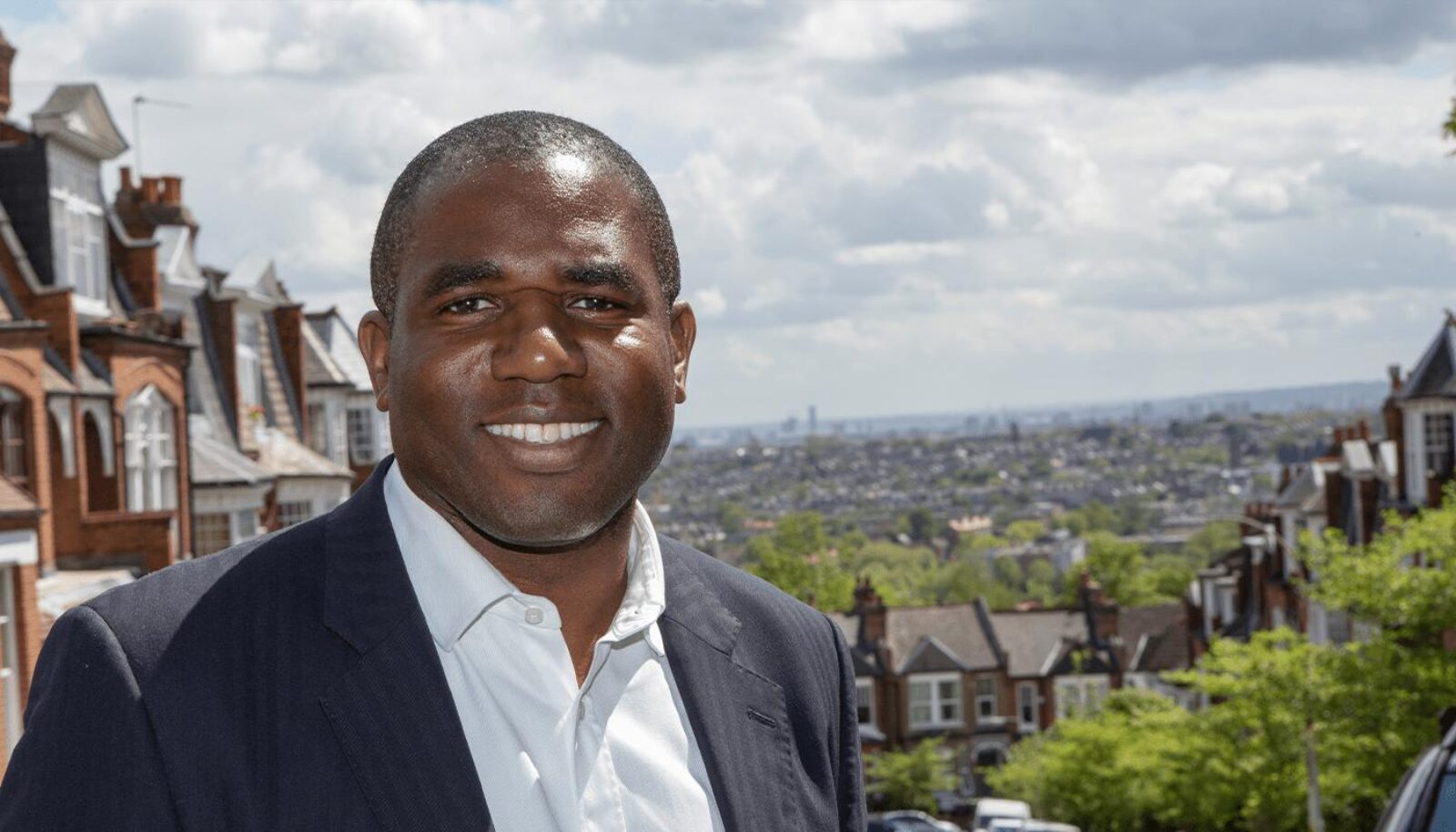 A younger David Lammy standing in his Tottenham constituency with Central London visible in the background.