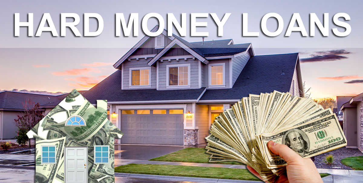 A hand holding cash in the foreground with a large house blurred in the background, representing real estate financing.